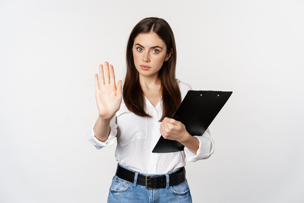 Mujer con una carpeta, haciendo un gesto de parar con la mano